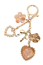 Load image into Gallery viewer, Keychain with floral, heart, and bow charms on a yellow background