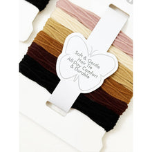 Load image into Gallery viewer, Neutral rolled hair ties displayed in assorted earthy tones on branded packaging
