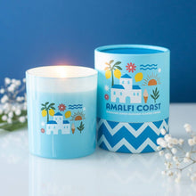 Load image into Gallery viewer, The Amalfi Coast Sparkling Lemon Blossom scented candle in blue Mediterranean-inspired vessel beside lit candle on white surface
